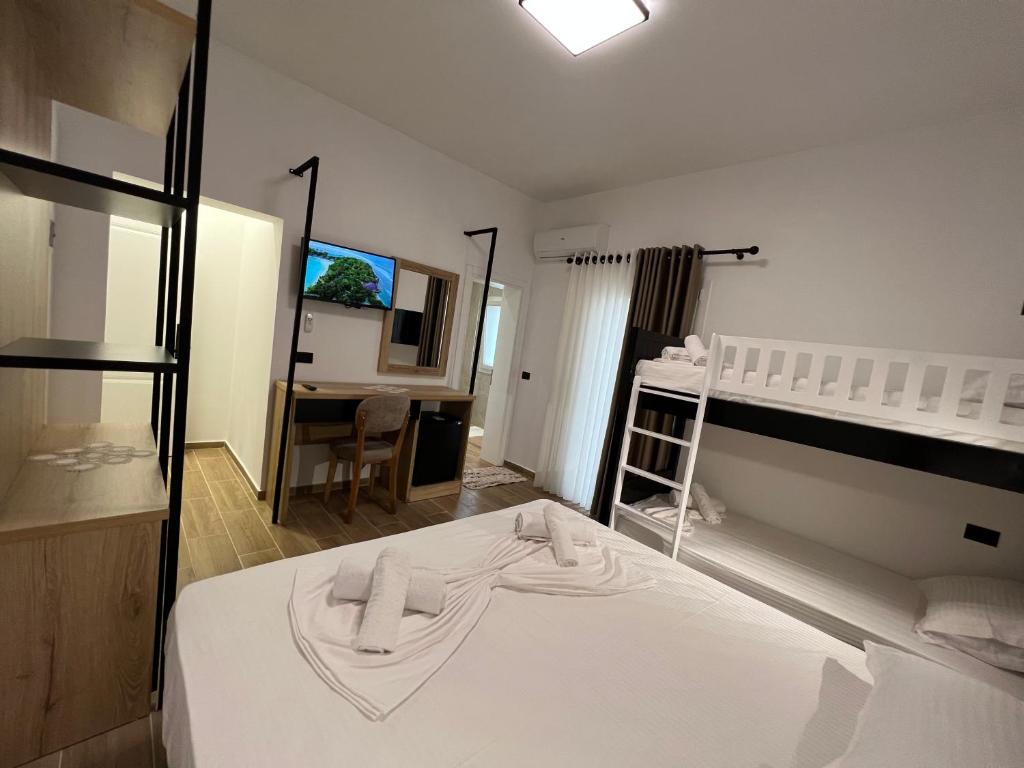 a bedroom with a white bed and a desk at Green Garden Villa in Durrës