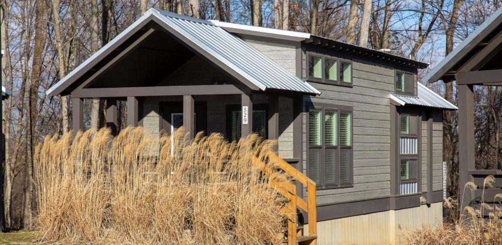 a small house with a black roof at Camp Cedar in Mason