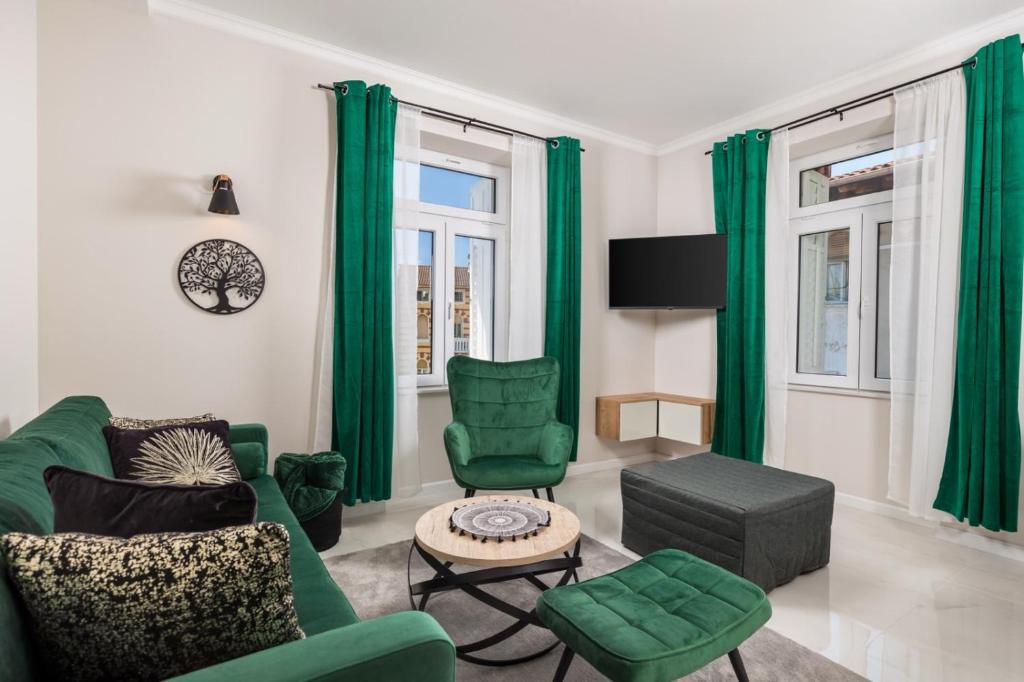 ein Wohnzimmer mit grünen Möbeln und grünen Vorhängen in der Unterkunft Deluxe Kvarner 2 in Lovran