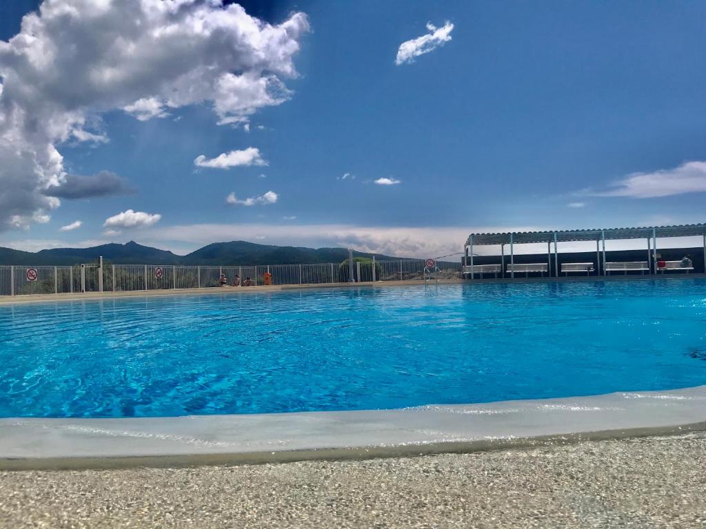une piscine d'eau bleue avec une jetée en arrière-plan dans l'établissement Villa Arizona, à Fréjus