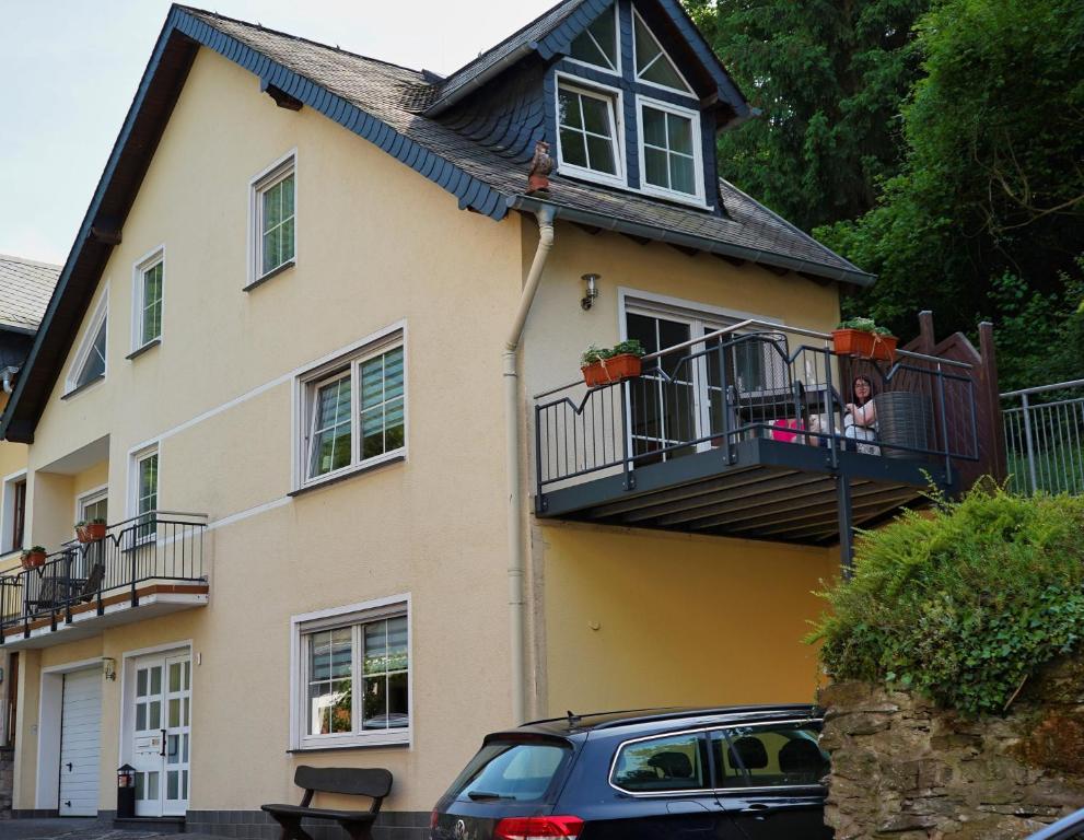 a house with a balcony and a car parked in front at Im Beilsteiner Mühlental in Beilstein