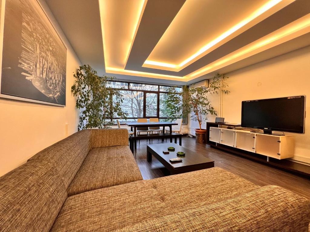 a living room with a couch and a tv at A Luxury Apt 170 m2 3 Bedroom 2 Bathroom at Bestekar Avenue at the heart of Ankara in Ankara