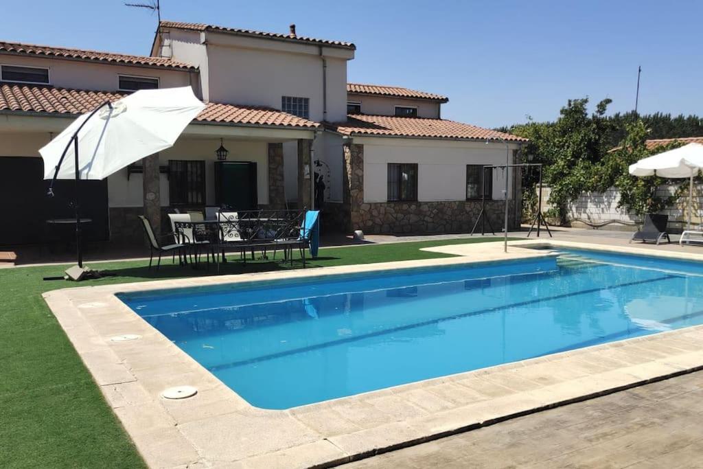 a swimming pool in front of a house at CASA RURAL EL ZARZOSO in Coria