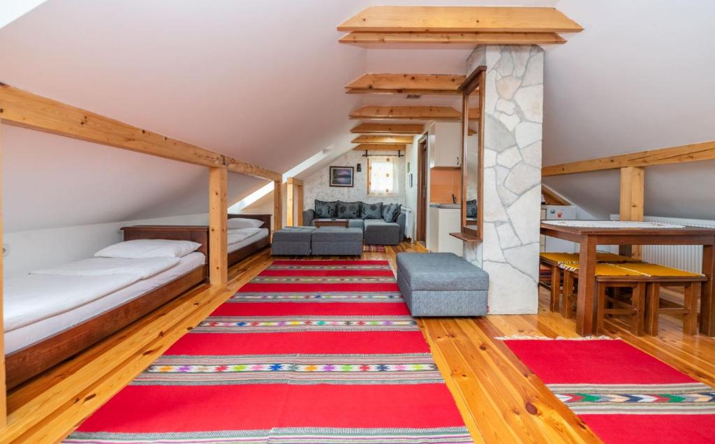 Cette chambre comprend 2 lits et un tapis rouge. dans l'établissement Guesthouse Sandra, à Kolašin