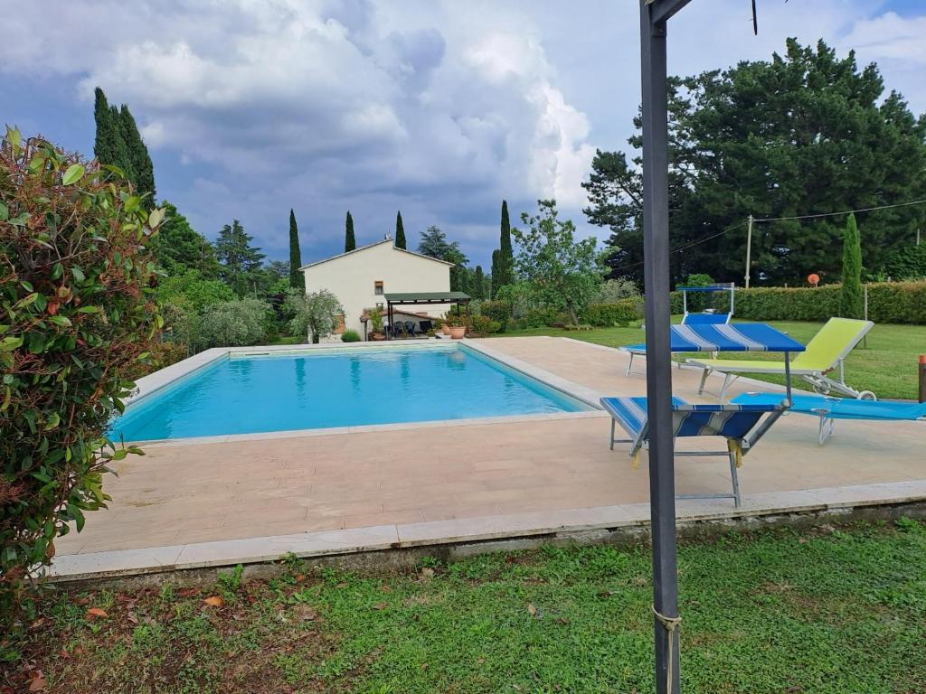a swimming pool with two chairs and a table next to it at CASA VACANZE L'OLIVO in Lubriano