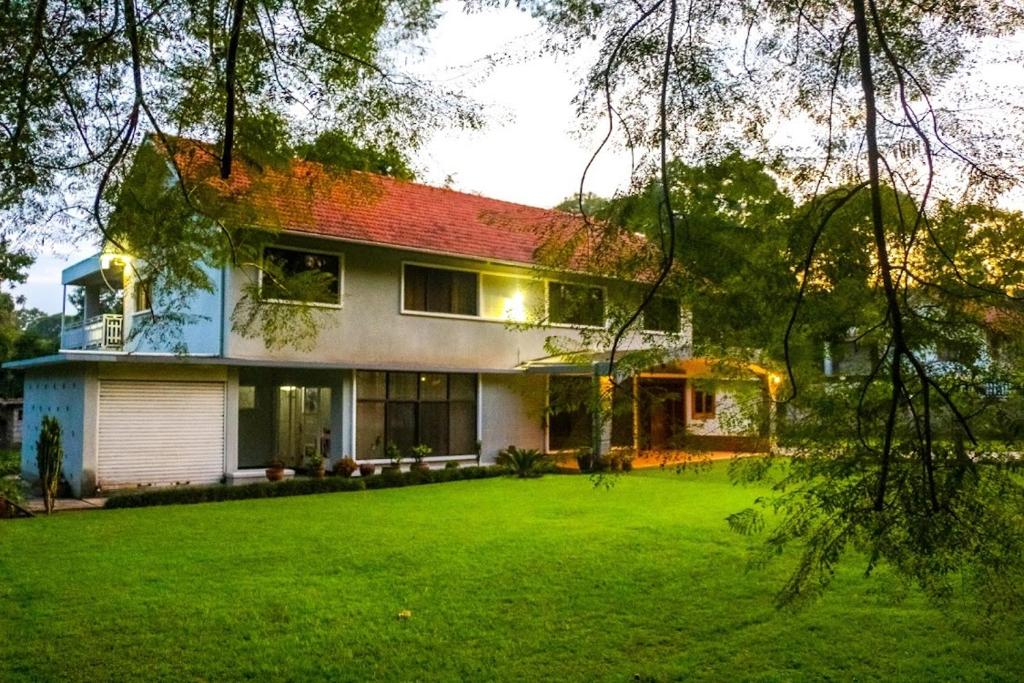 une maison avec une pelouse verte devant elle dans l'établissement Nyumbani Palace Arusha, à Arusha