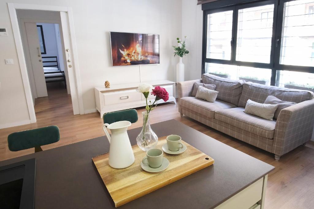 una sala de estar con un jarrón de flores sobre una mesa en Ibanova Homes Casco Antiguo 2 en Valencia