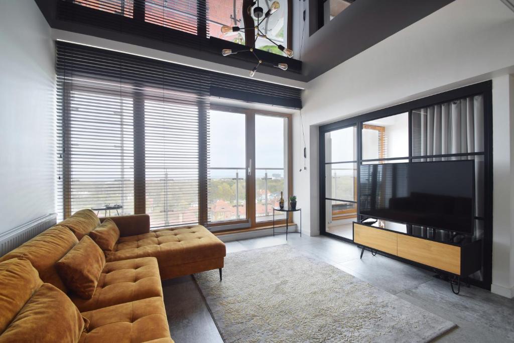 a living room with a couch and a flat screen tv at Horizon.12 Platan Tower in Świnoujście