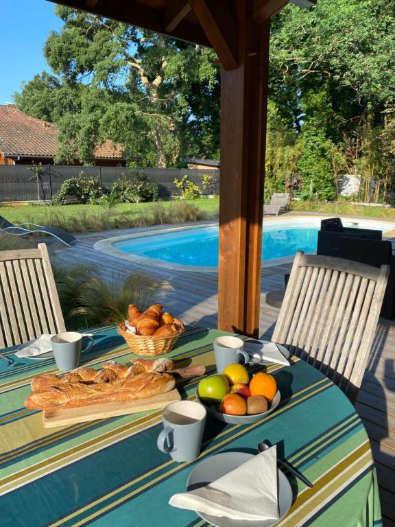 einen Tisch mit einer Obstschale neben einem Pool in der Unterkunft Les cabanes de l'océan, Villa confort proche plage sauvage in Messanges