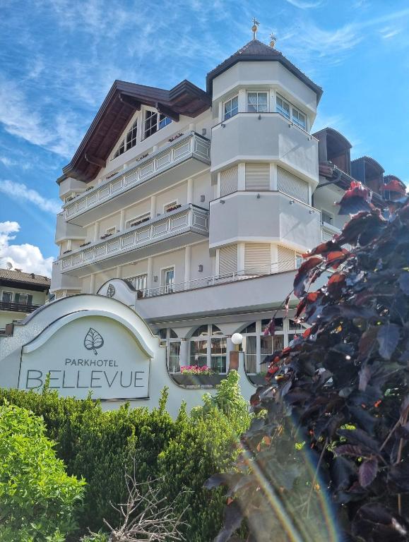 duży biały budynek z znakiem przed nim w obiekcie Park Hotel Bellevue w mieście Dobbiaco