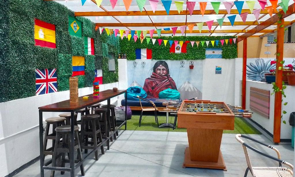 Habitación con mesa, sillas y un cuadro en la pared. en Dragonfly Hostels Miraflores, en Lima