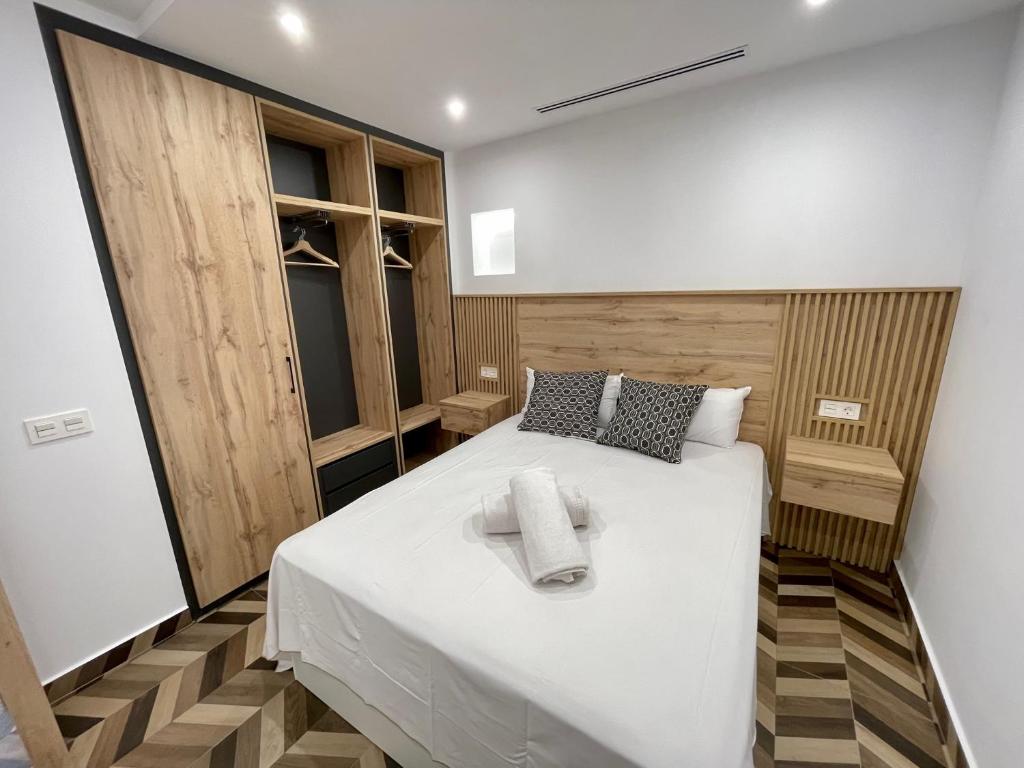1 dormitorio con 1 cama blanca grande y toallas. en Loft Concejo Plaza Mayor, en Salamanca