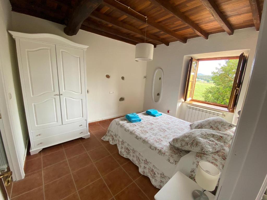 1 dormitorio con cama blanca y ventana en Apartamentos El Campo, en Castropol