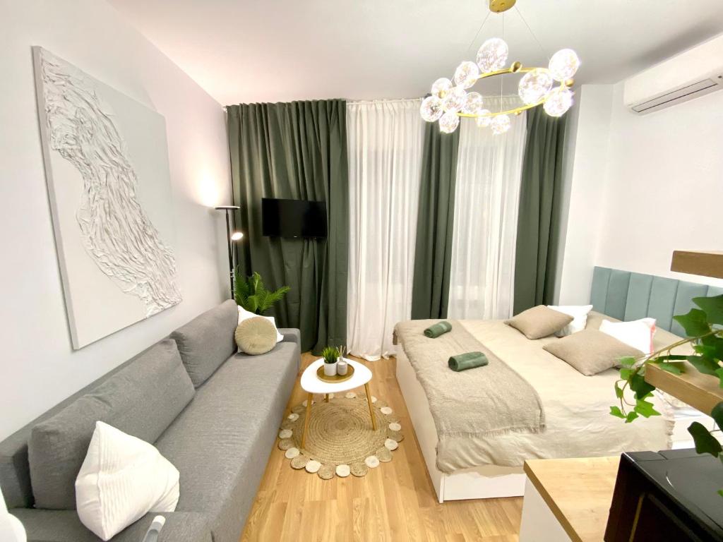 uma sala de estar com um sofá e uma cama em BRAND NEW Design studio Emerald - old town A/C em Bratislava