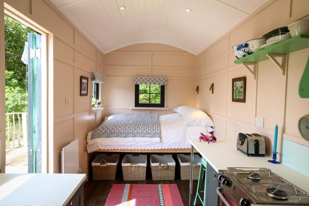 a small kitchen with a bed in a tiny house at Lapin Cottage in Long Bredy