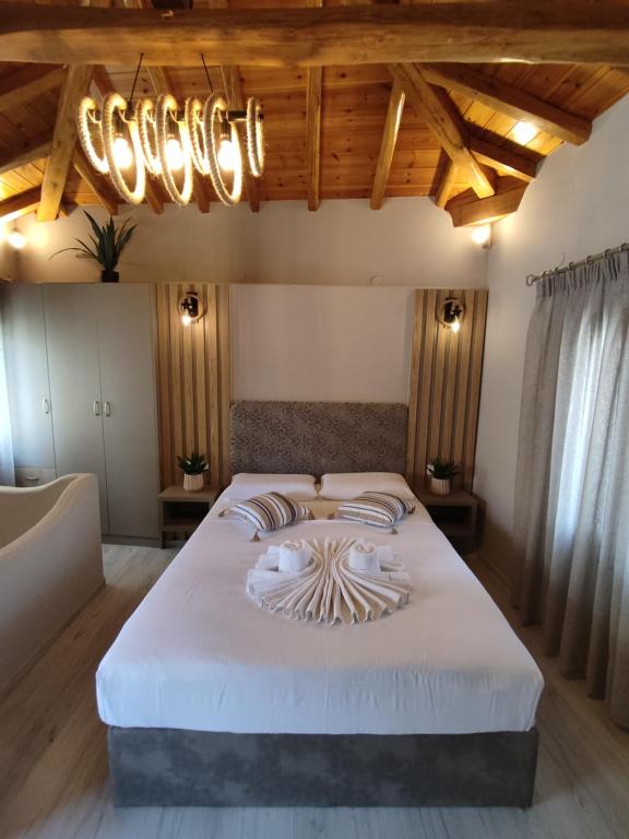 1 dormitorio con 1 cama blanca grande con lámpara de araña en VILLA ELLIS SKIATHOS en Skíathos