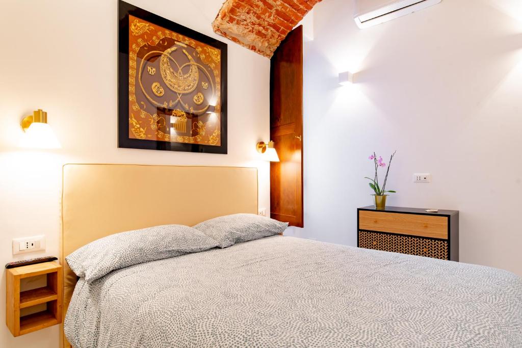 1 dormitorio con 1 cama y una pintura en la pared en Cavour central apartment, en Turín