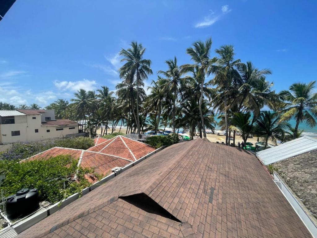 um telhado de um edifício com palmeiras ao fundo em Casa MIA em Cabarete
