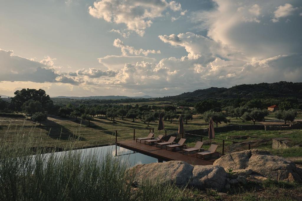 un groupe de chaises assises sur un pont au-dessus d'un étang dans l'établissement Bode Country House, à Monsanto