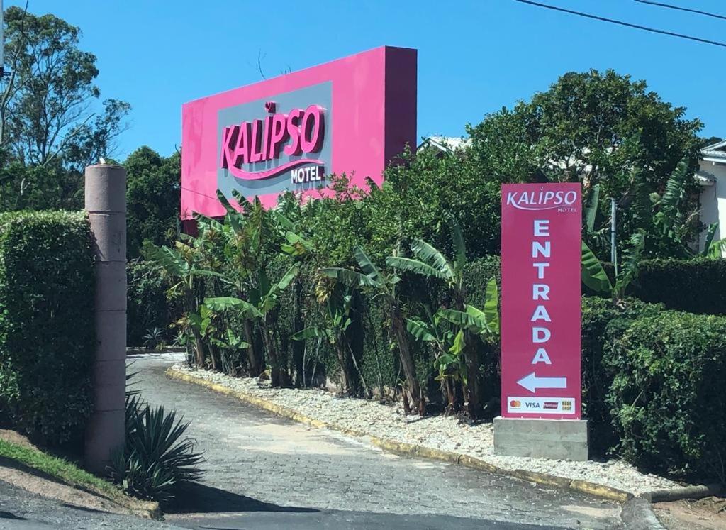 um sinal para um motel kwikkoz ao lado de uma estrada em Motel Kalipso em São José
