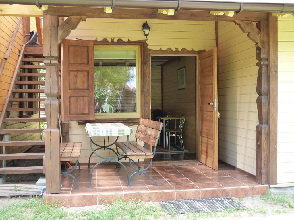 a porch with a table and chairs on a house at U Kaczorka in Ruciane-Nida