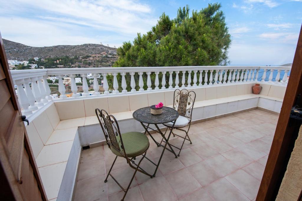 a patio with a table and chairs on a balcony at BunnyFoot: Country house of 135 sqm in Leros. in Panteli