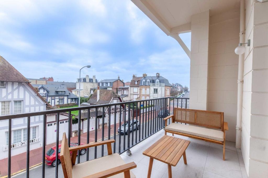 un balcon avec un banc et une vue sur une ville dans l'établissement 2-bedroom apartment with balcony near Hippodrome, à Deauville