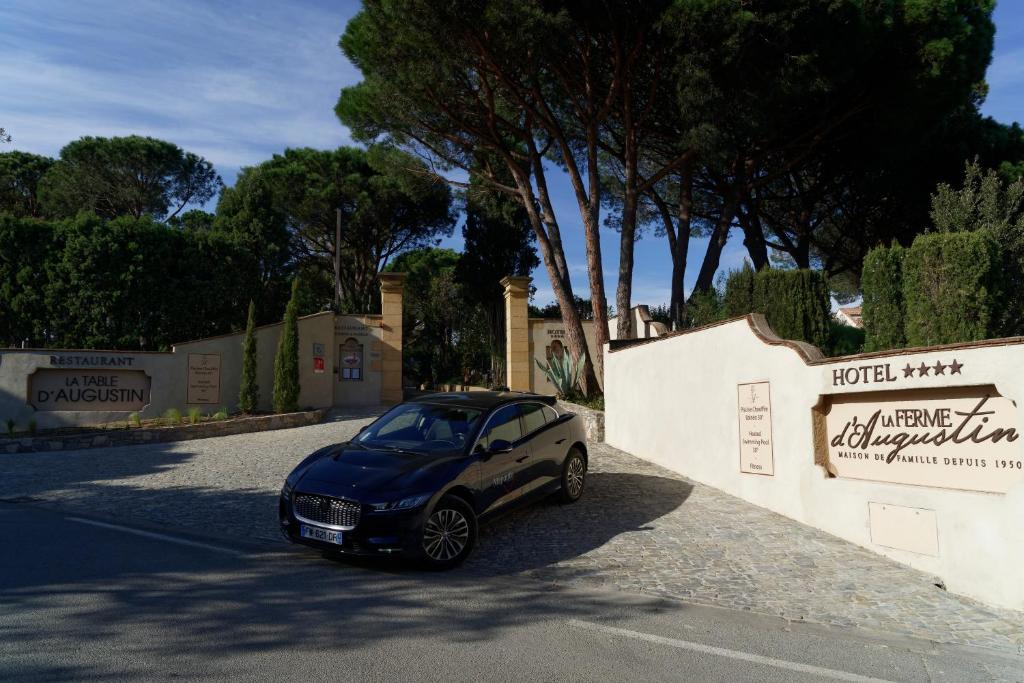 a small blue car parked next to a wall at La Ferme D'Augustin in Saint-Tropez