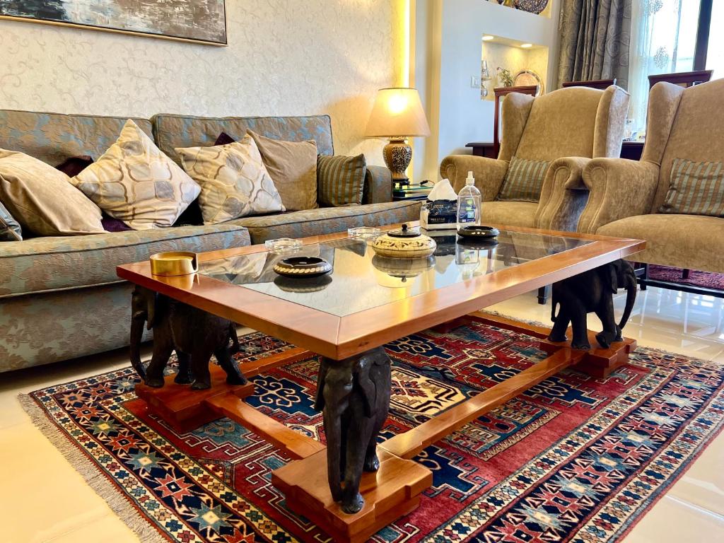 a living room with a coffee table on a rug at Elegant duplex with pool frontAUC in Cairo