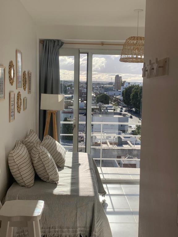 a room with a bed and a large window at Depto Caleta Madryn in Puerto Madryn