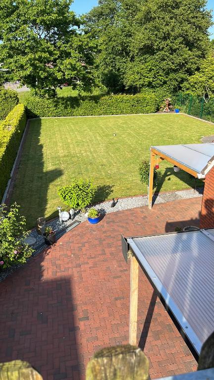 a patio with a table and a field of grass at Papenburger Gästehaus in Papenburg