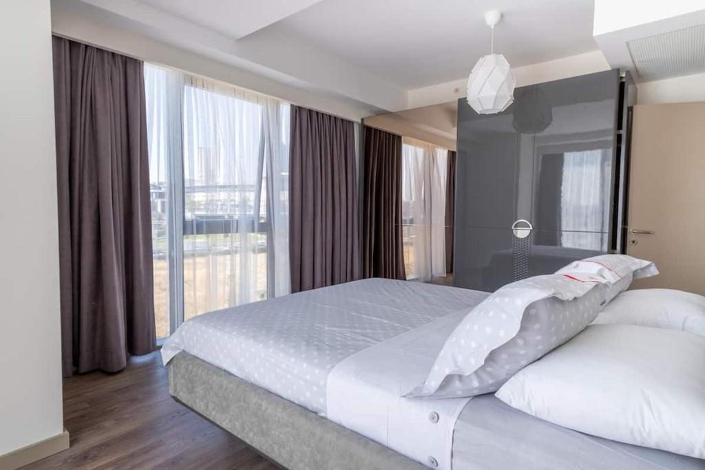 - une chambre avec un lit blanc et une grande fenêtre dans l'établissement Lüx&central, à Istanbul