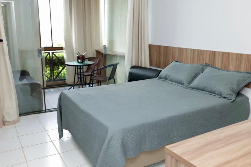 um quarto com uma cama, uma mesa e uma varanda em Flat na Fazenda Monte Castelo Gravatá Sairé - Mod 12 - Flat 9 em Gravatá