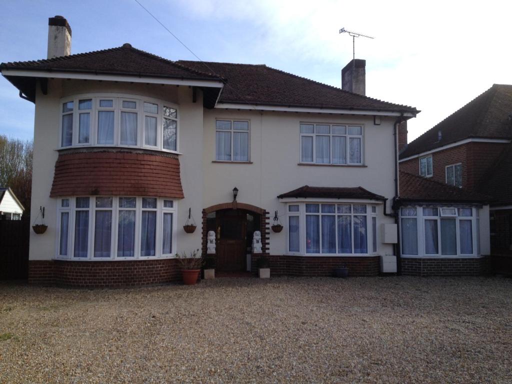 a large white house with blue windows at LA B&B in Chichester