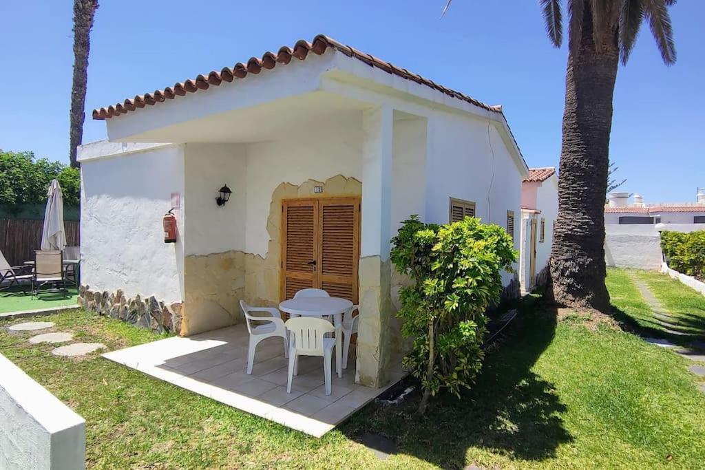 a small white house with a table and chairs at Precioso Bungalow 12 in Playa del Ingles