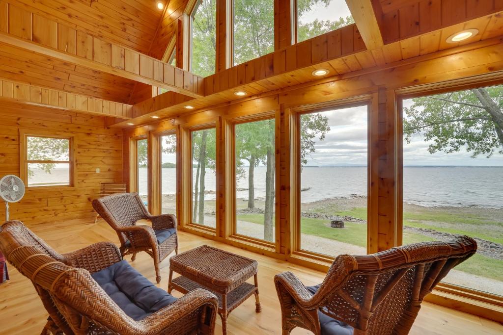 een woonkamer met stoelen en ramen in een hut bij Lake Champlain Vacation Rental with Boat Dock! in Melville Landing