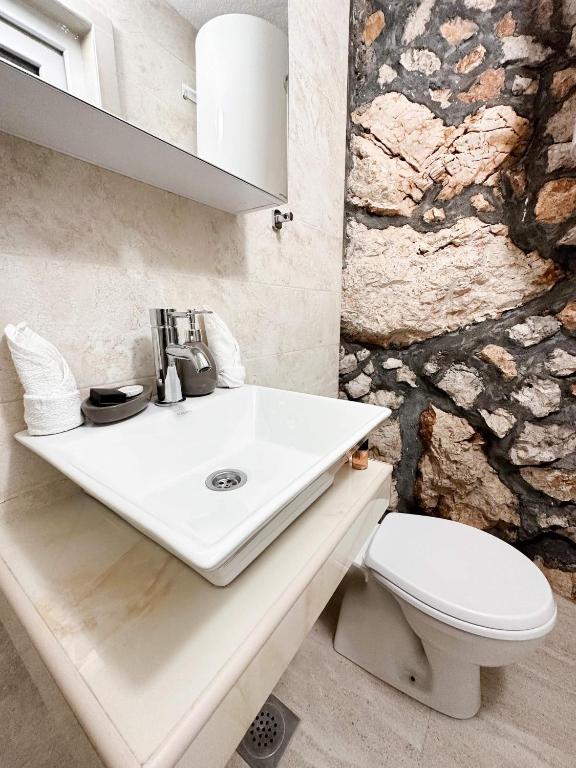 a bathroom with a sink and a toilet at Harmonia Bungalows & Pool in Sveti Stefan