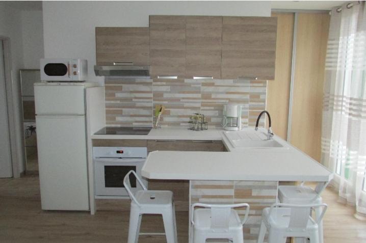 a kitchen with a white counter and white appliances at Appartement T2 neuf Bages centre in Bages