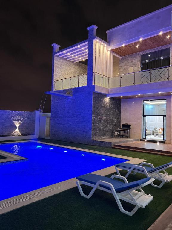 eine Villa mit einem Pool in der Nacht in der Unterkunft Sky ittin سما إتين in Salalah