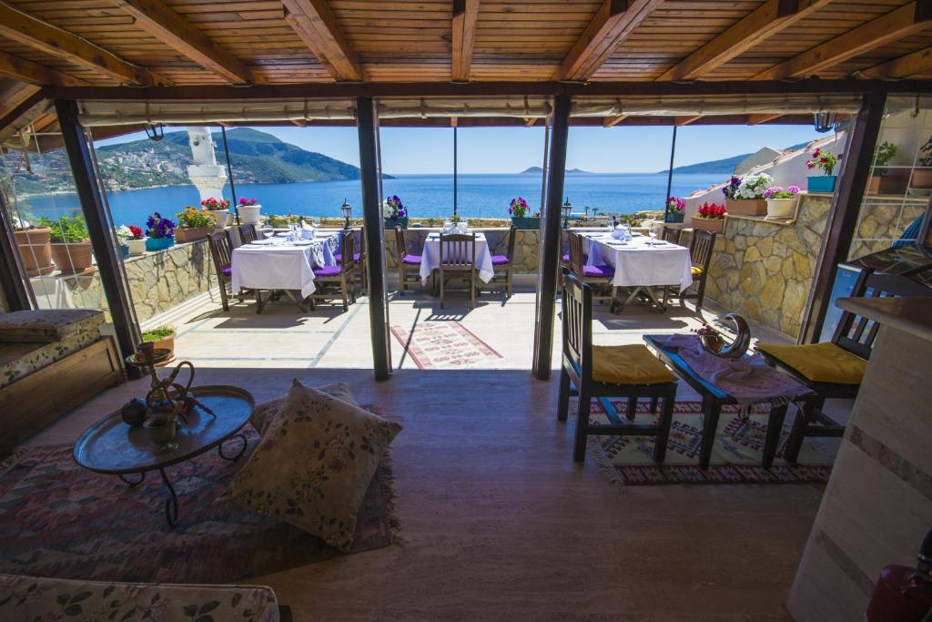 ein Restaurant mit Tischen und Stühlen und Meerblick in der Unterkunft Kleo Boutique Otel Kalkan in Kalkan