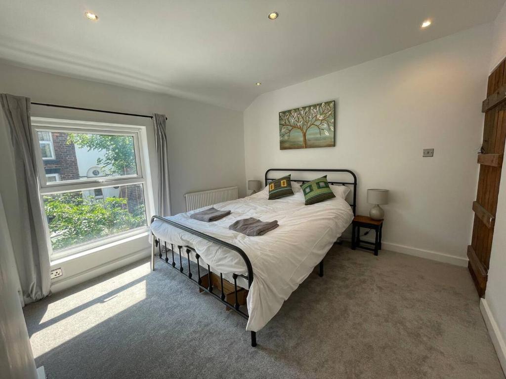 a bedroom with a bed and a large window at Tucked away house in Macclesfield in Macclesfield