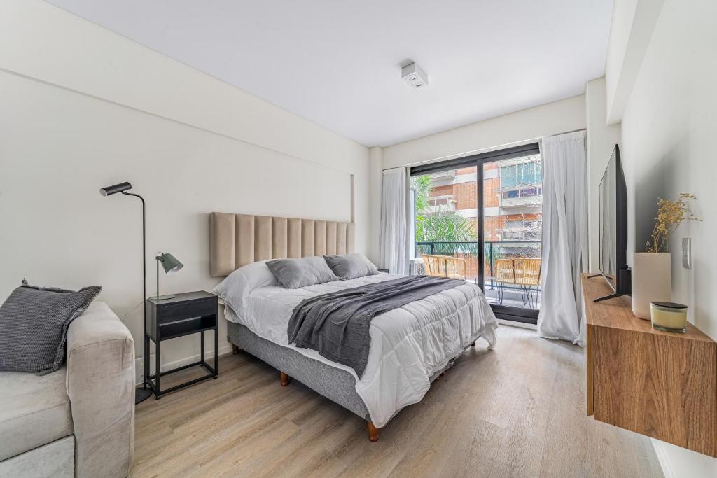 a bedroom with a bed and a large window at La Vie Suite Cañitas in Buenos Aires