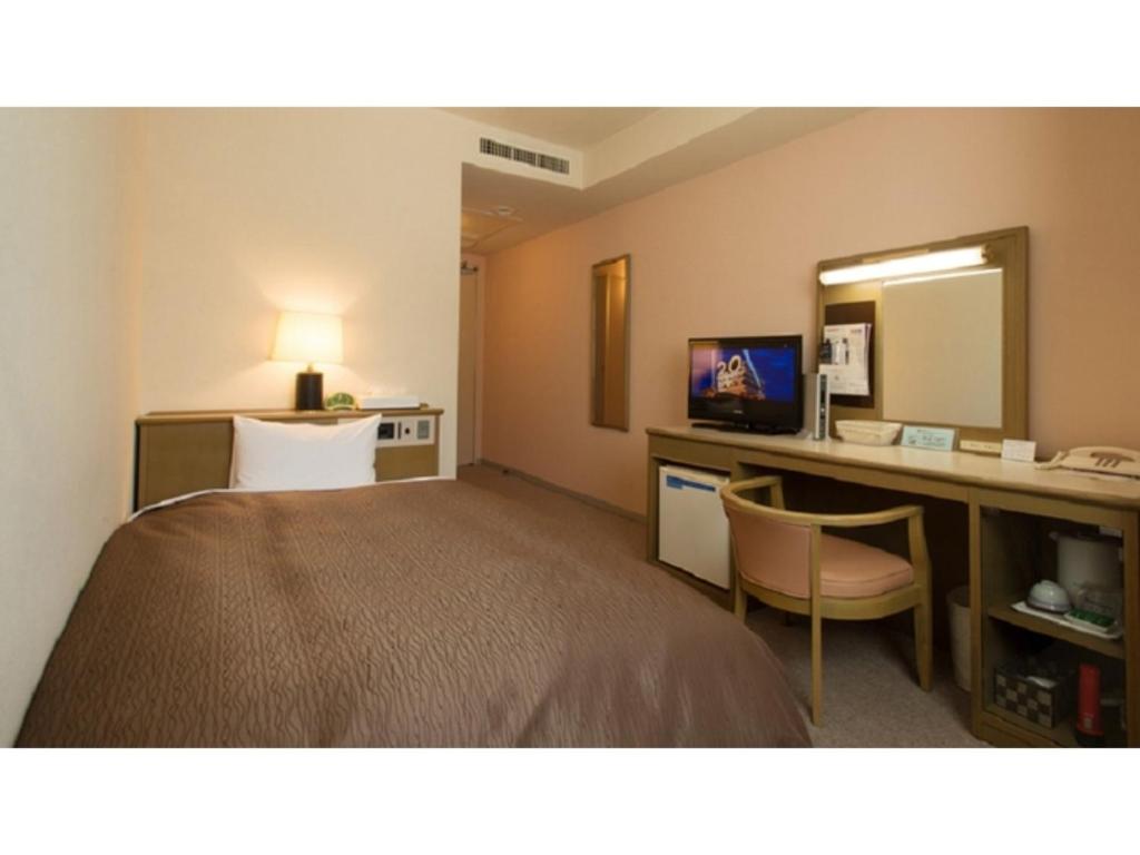 a hotel room with a bed and a desk and a mirror at Hotel Yassa - Vacation STAY 08840v in Mihara