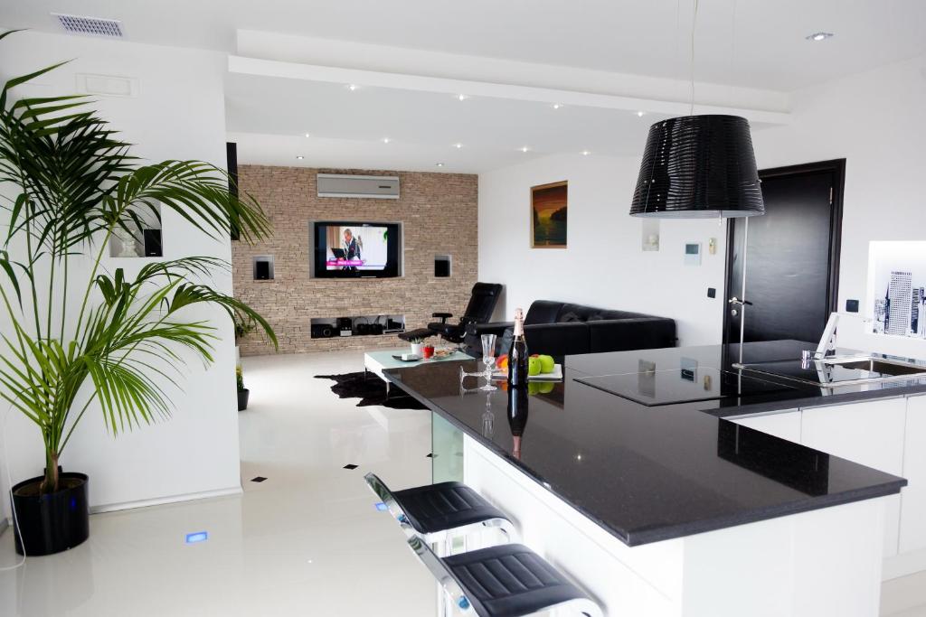 a kitchen with a black counter and a living room at Senator in Ulcinj