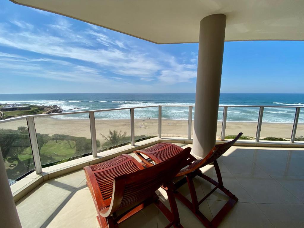 a chair on a balcony with a view of the ocean at Lucien Sands 602 in Margate