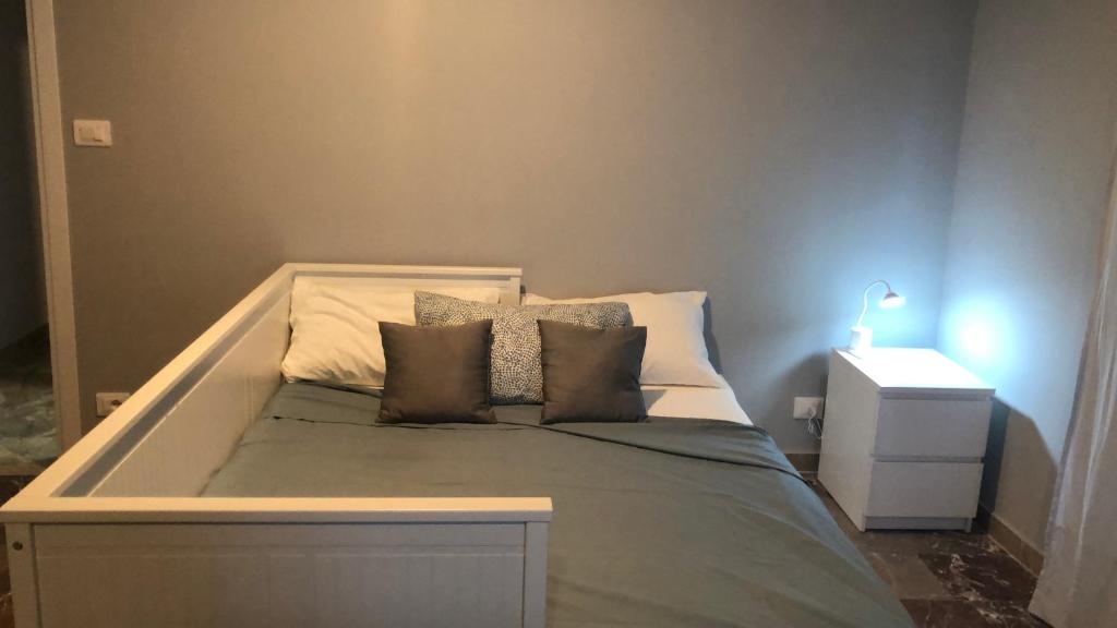 Bett in einem Zimmer mit einem großen Bett mit Kissen in der Unterkunft APPARTAMENTO FRONTE MARE ACi TREZZA in Aci Castello