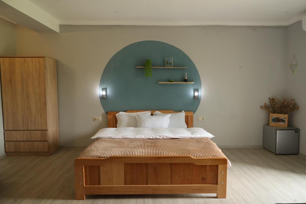 a bedroom with a large bed with a blue wall at hOlarooms N2 in Tʼianetʼi