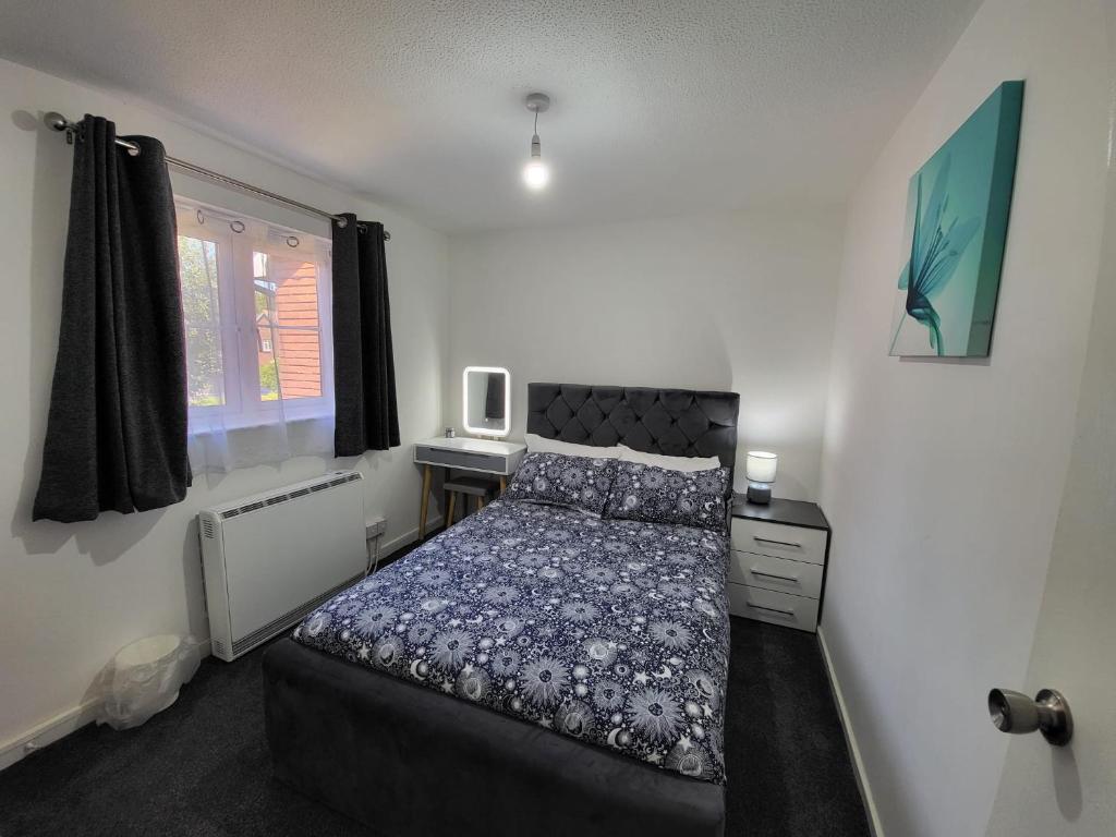 um quarto com uma cama, uma secretária e uma janela em Delight Apartment, Close to Excel, London City Airport & O2! em Londres