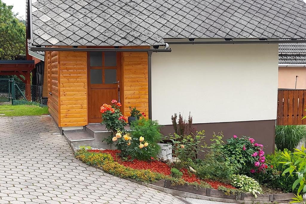 una pequeña casa con flores delante en Apartment Pr Dev, en Begunje na Gorenjskem