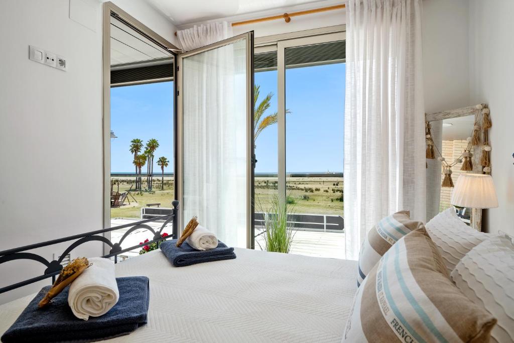 um quarto com uma cama e vista para o oceano em 1ª LÍNEA DE PLAYA. Apartamento: LA CALMA em Comarruga